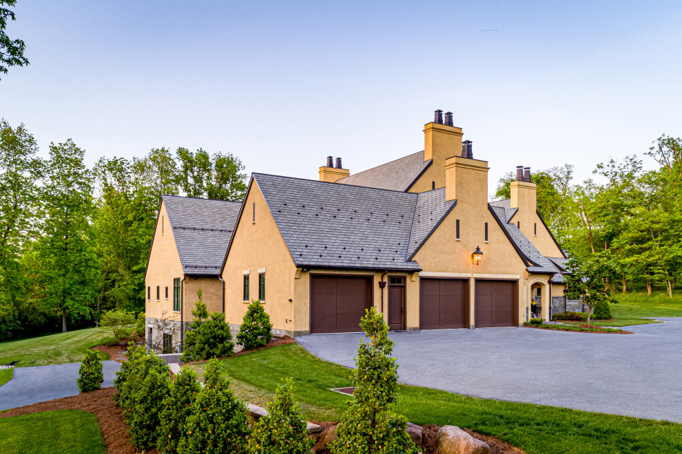 Foto de fachada de casa beige y gris extra grande de tres plantas con revestimiento de aglomerado de cemento, tejado a dos aguas, tejado de teja de madera y teja