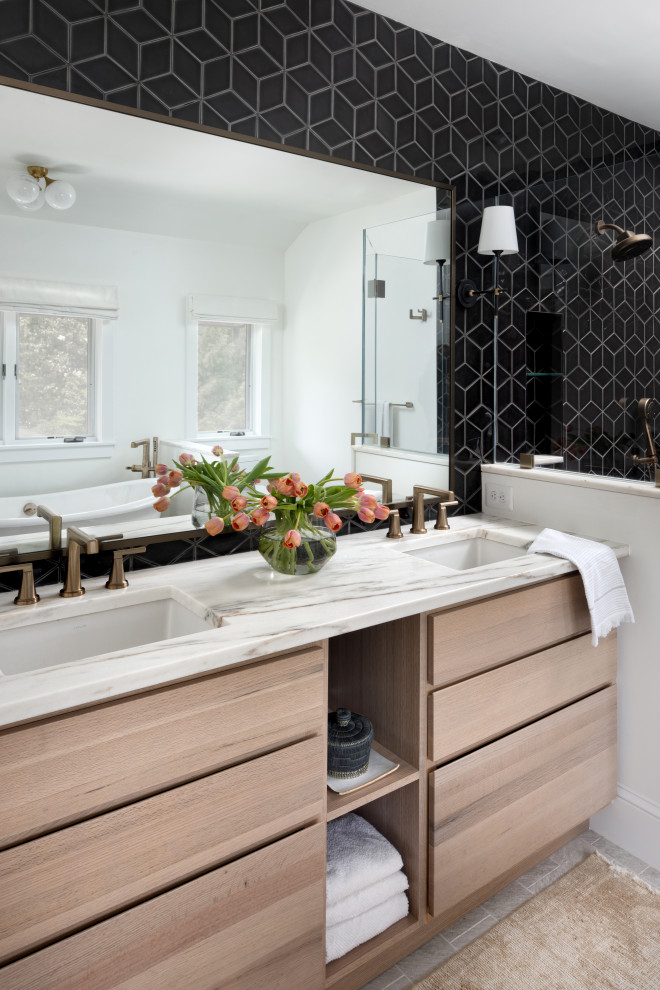 Foto de cuarto de baño doble actual con armarios con paneles lisos, puertas de armario de madera clara, baldosas y/o azulejos negros y lavabo bajoencimera