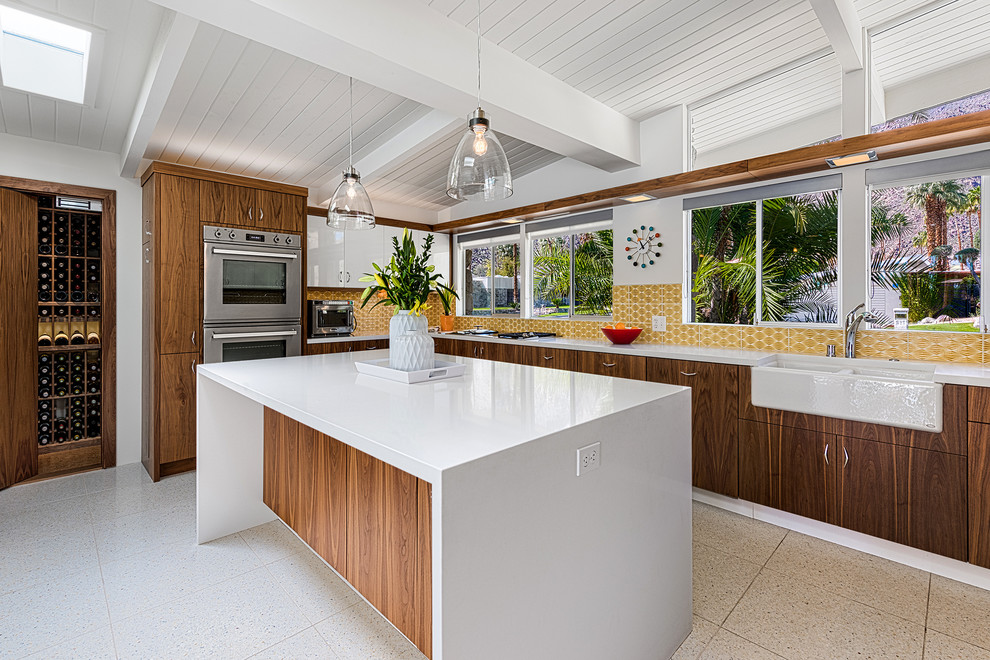 Inspiration for a mid-sized midcentury u-shaped eat-in kitchen in Other with a farmhouse sink, flat-panel cabinets, medium wood cabinets, quartzite benchtops, yellow splashback, ceramic splashback, stainless steel appliances and with island.