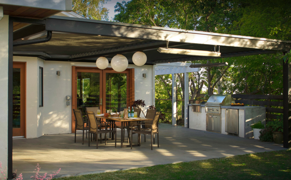 Immagine di un grande patio o portico design dietro casa con pavimentazioni in pietra naturale e una pergola