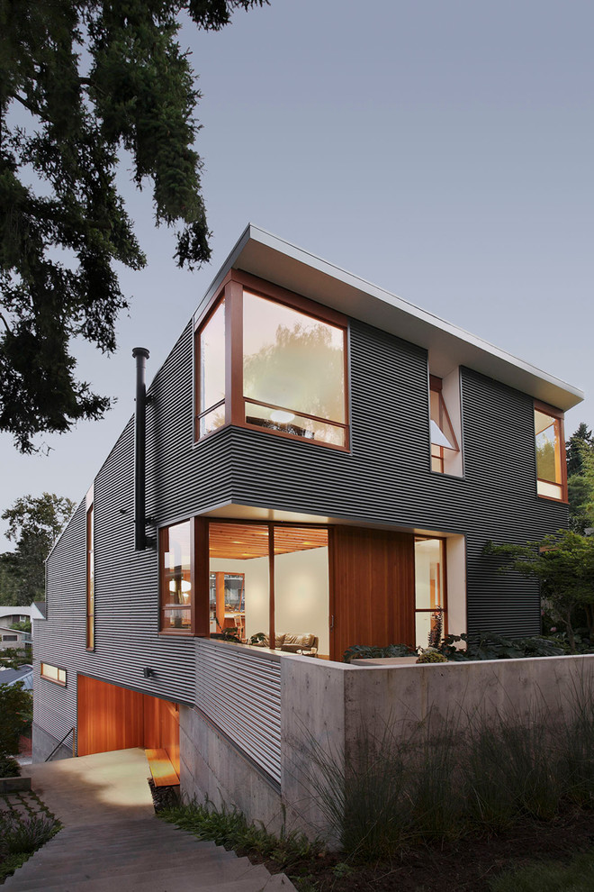 Photo of a mid-sized modern two-storey grey exterior in Seattle with mixed siding and a flat roof.