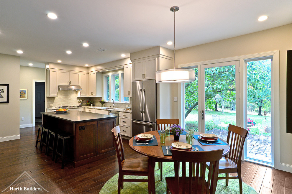 Inspiration for a mid-sized transitional l-shaped medium tone wood floor eat-in kitchen remodel in Philadelphia with an undermount sink, recessed-panel cabinets, white cabinets, granite countertops, gray backsplash, glass tile backsplash, stainless steel appliances and an island