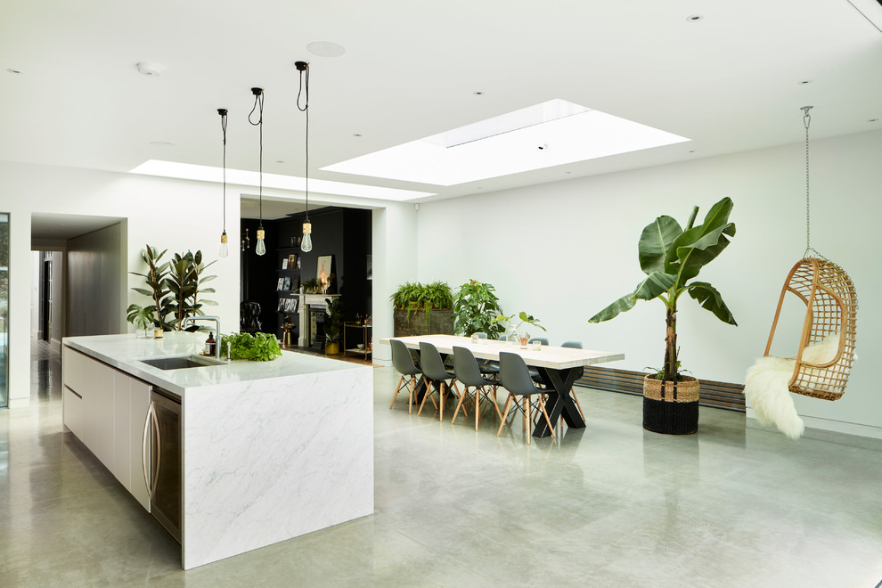 Photo of a contemporary open plan kitchen in London with marble benchtops and with island.