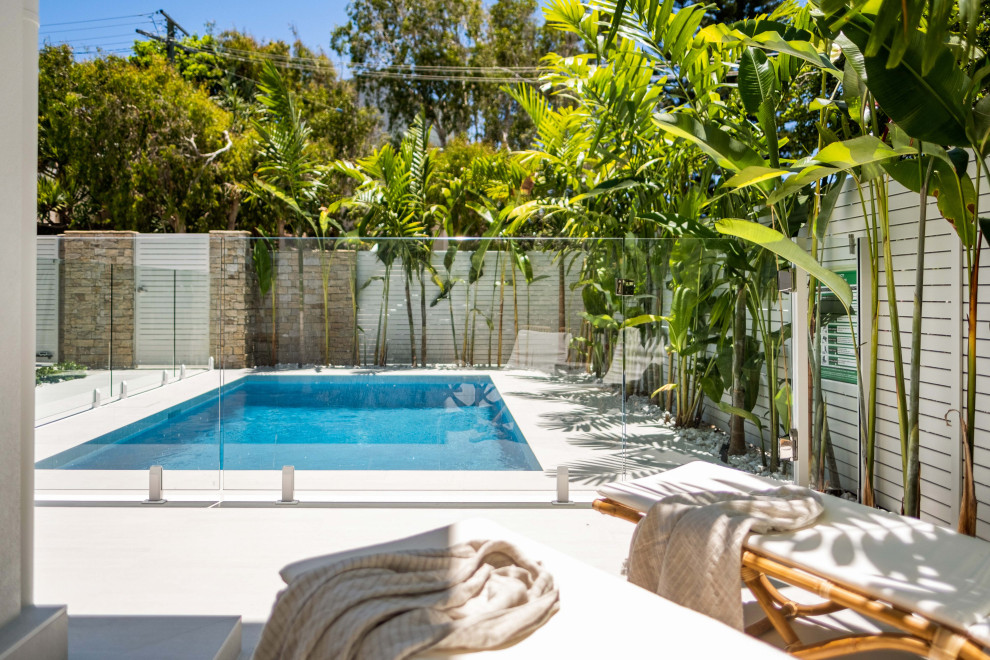 Immagine di una piccola piscina monocorsia stile marino rettangolare davanti casa con paesaggistica bordo piscina e piastrelle