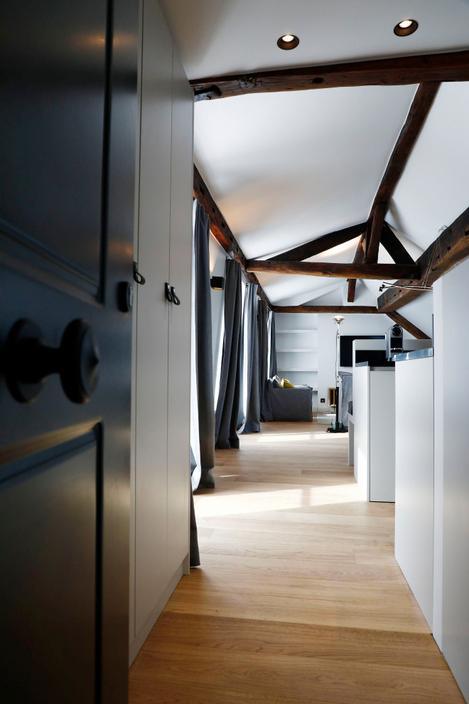 Mittelgroßes Modernes Foyer mit weißer Wandfarbe, hellem Holzboden, grauer Haustür und freigelegten Dachbalken in Paris