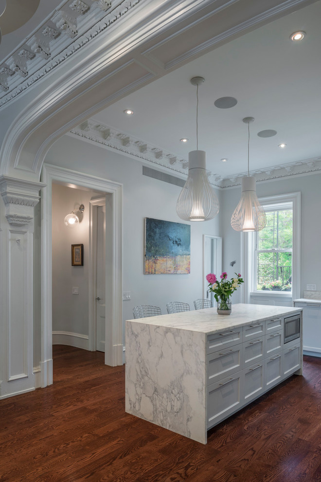 Inspiration for an expansive traditional l-shaped open plan kitchen in New York with an undermount sink, shaker cabinets, marble benchtops, white splashback, marble splashback, stainless steel appliances, dark hardwood floors and with island.