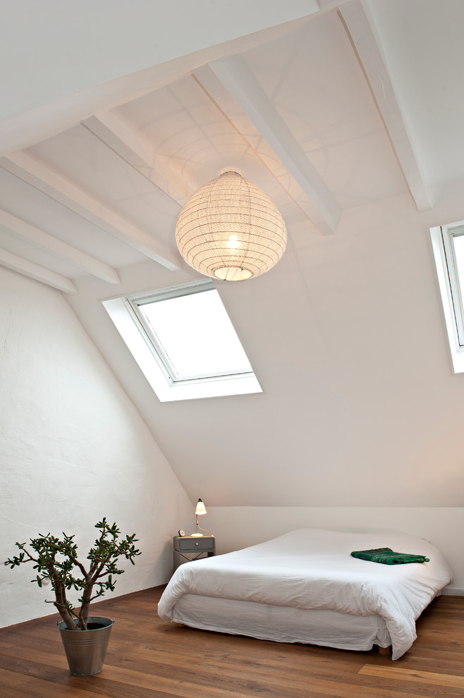 Photo of a large contemporary bedroom in Rennes with white walls and medium hardwood floors.