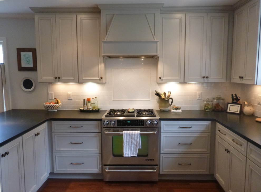 This is an example of a large traditional u-shaped eat-in kitchen in Other with an undermount sink, recessed-panel cabinets, grey cabinets, granite benchtops, white splashback, subway tile splashback, stainless steel appliances, medium hardwood floors and a peninsula.