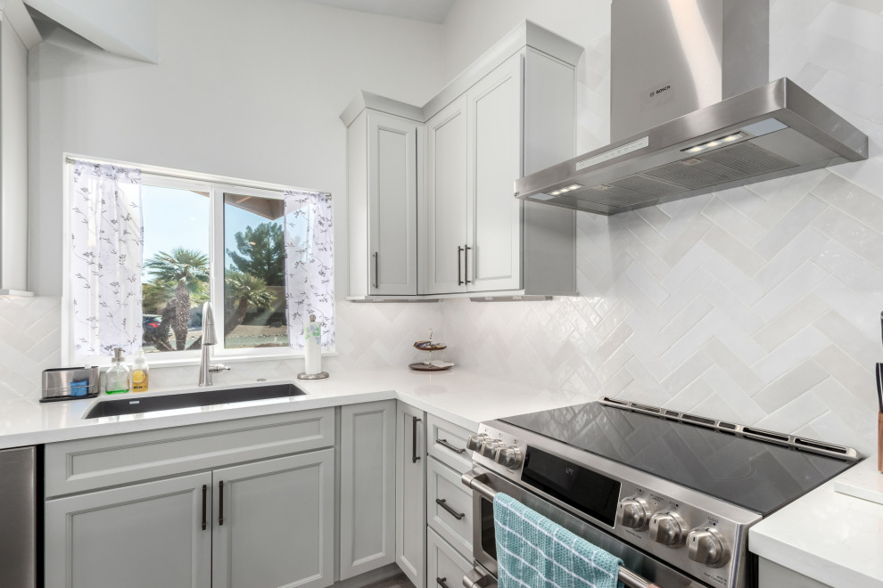Mid-sized transitional porcelain tile and gray floor eat-in kitchen photo in Phoenix with an undermount sink, shaker cabinets, gray cabinets, quartz countertops, white backsplash, subway tile backsplash, stainless steel appliances, an island and white countertops