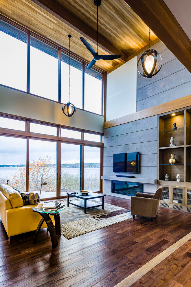 This is an example of a mid-sized contemporary formal enclosed living room in Vancouver with grey walls, a ribbon fireplace, a concrete fireplace surround, a wall-mounted tv and medium hardwood floors.