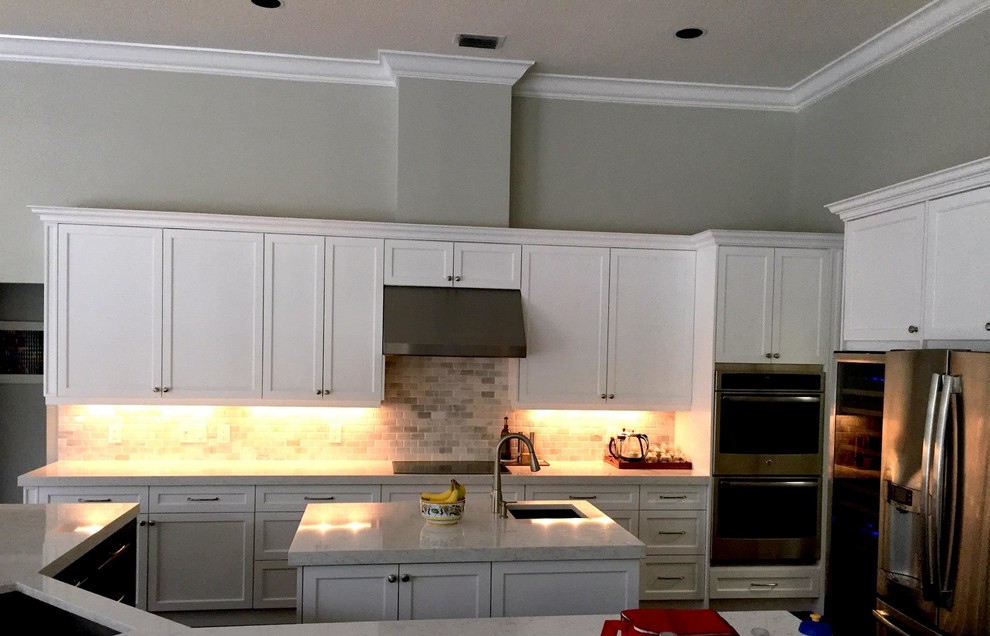 Open concept kitchen - large transitional u-shaped dark wood floor and brown floor open concept kitchen idea in Miami with a single-bowl sink, shaker cabinets, white cabinets, quartzite countertops, multicolored backsplash, stone tile backsplash, stainless steel appliances and two islands