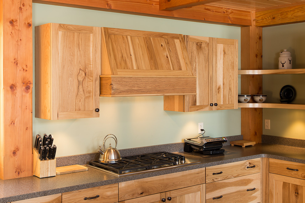 Inspiration for a large rustic u-shaped dark wood floor eat-in kitchen remodel in Burlington with an undermount sink, shaker cabinets, medium tone wood cabinets, solid surface countertops, stainless steel appliances and an island