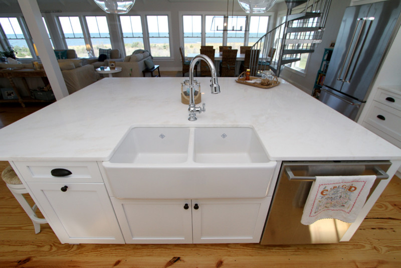 Design ideas for a mid-sized beach style l-shaped separate kitchen in Boston with a double-bowl sink, shaker cabinets, white cabinets, marble benchtops, stainless steel appliances, light hardwood floors and with island.