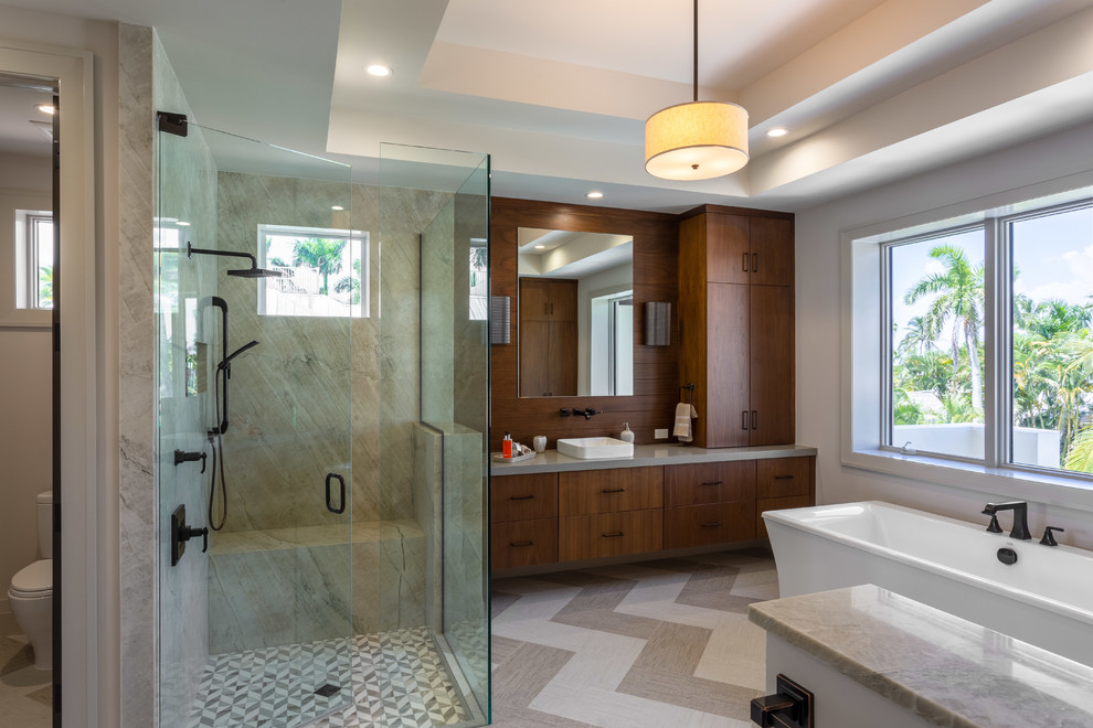 Inspiration for a contemporary master bathroom in Other with flat-panel cabinets, dark wood cabinets, a freestanding tub, a corner shower, a two-piece toilet, beige tile, white walls, a vessel sink, beige floor, a hinged shower door and grey benchtops.
