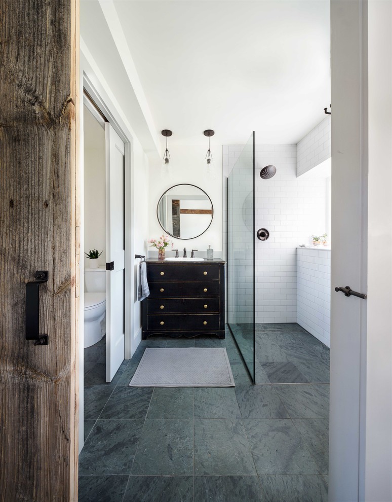 Photo of a country master bathroom in Boston with furniture-like cabinets, black cabinets, an open shower, white tile, subway tile, slate floors, a drop-in sink and an open shower.