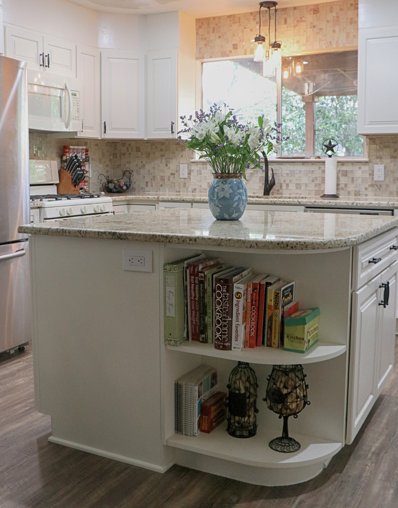 This is an example of a mid-sized traditional l-shaped separate kitchen in Austin with shaker cabinets, granite benchtops, multi-coloured splashback, glass tile splashback, stainless steel appliances, with island, beige benchtop, an undermount sink, white cabinets, medium hardwood floors and brown floor.