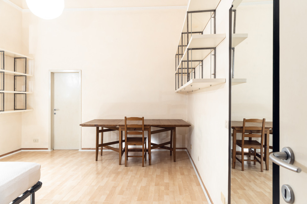 Immagine di una piccola camera matrimoniale design con pareti beige, pavimento in laminato e pavimento beige