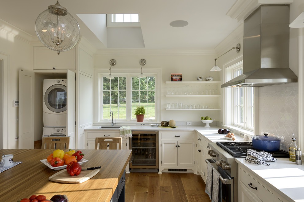 Inspiration for a country separate kitchen in New York with an undermount sink, recessed-panel cabinets, white cabinets, white splashback, stainless steel appliances, medium hardwood floors and with island.