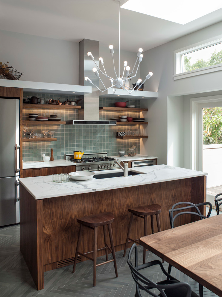 Photo of a contemporary galley eat-in kitchen in San Francisco with an undermount sink, flat-panel cabinets, dark wood cabinets, blue splashback, stainless steel appliances and with island.