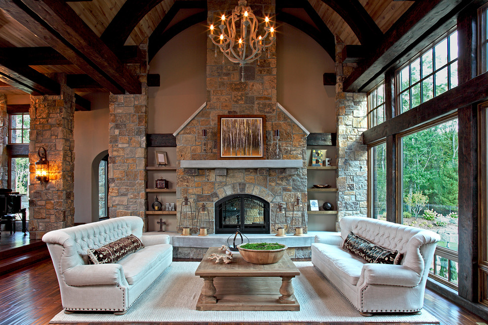 Inspiration for a large country open concept family room in Minneapolis with brown walls, dark hardwood floors, a two-sided fireplace, a stone fireplace surround and no tv.