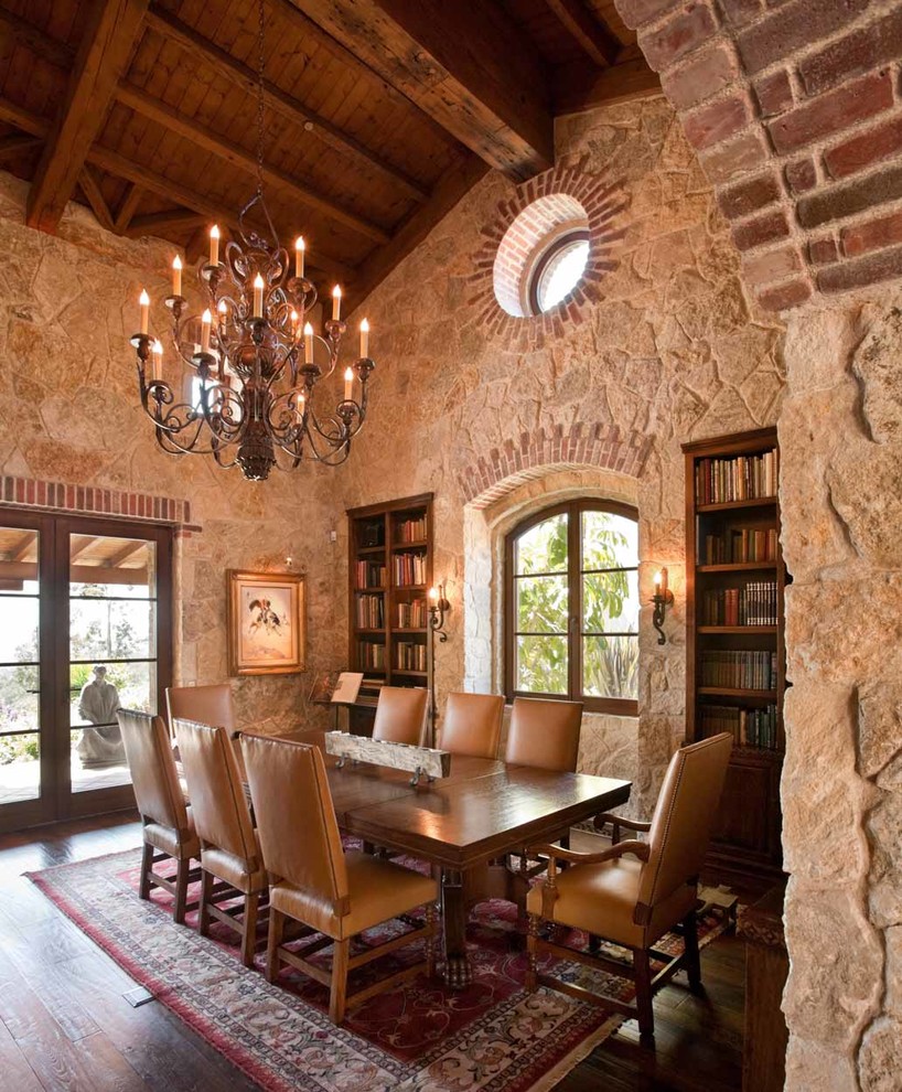This is an example of a mediterranean dining room in San Diego with beige walls, dark hardwood floors and brown floor.