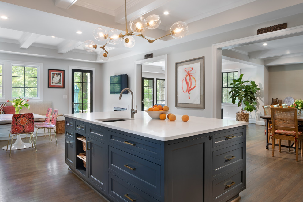 Inspiration for a large transitional l-shaped open plan kitchen in DC Metro with an undermount sink, shaker cabinets, white cabinets, quartz benchtops, white splashback, ceramic splashback, stainless steel appliances, medium hardwood floors, with island, brown floor and white benchtop.