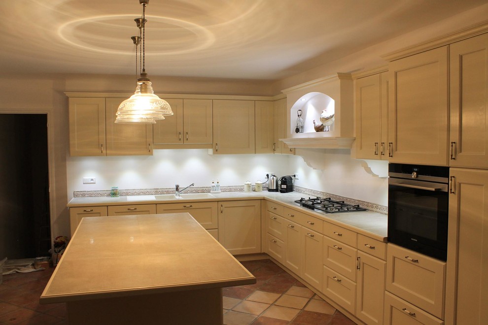 Inspiration for a large traditional l-shaped open plan kitchen in Nice with a double-bowl sink, recessed-panel cabinets, beige cabinets, tile benchtops, multi-coloured splashback, travertine splashback, stainless steel appliances, terra-cotta floors, with island and multi-coloured floor.