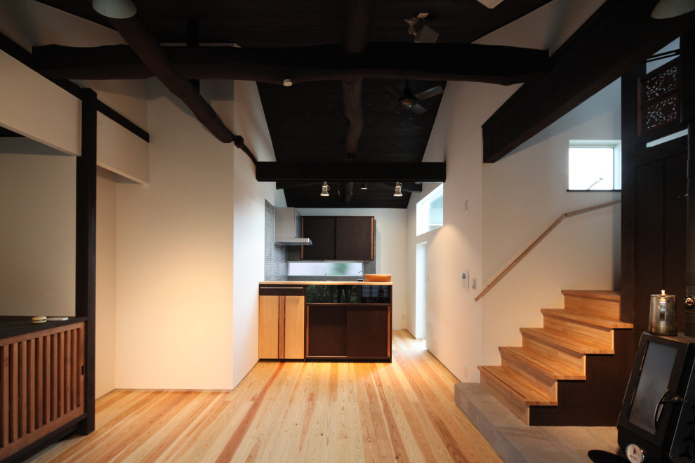 Photo of a mid-sized traditional galley open plan kitchen in Other with a single-bowl sink, beaded inset cabinets, dark wood cabinets, stainless steel benchtops, black splashback, timber splashback, stainless steel appliances, painted wood floors, with island, multi-coloured floor, multi-coloured benchtop and exposed beam.