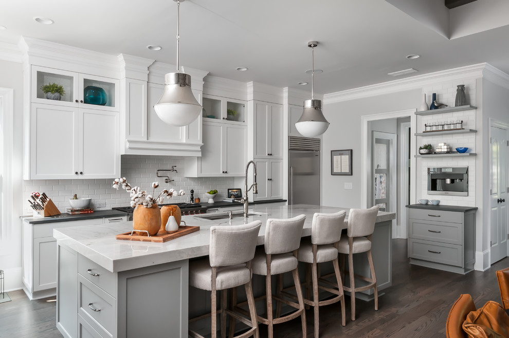 Design ideas for a transitional galley eat-in kitchen in Atlanta with a single-bowl sink, shaker cabinets, granite benchtops, white splashback, marble splashback, stainless steel appliances, dark hardwood floors, with island, brown floor, black benchtop and grey cabinets.