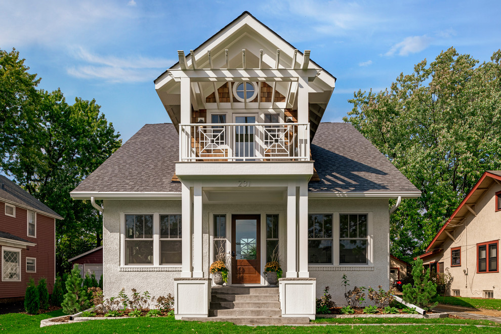 This is an example of a small traditional two-storey white house exterior in Minneapolis with mixed siding, a shingle roof and a gable roof.
