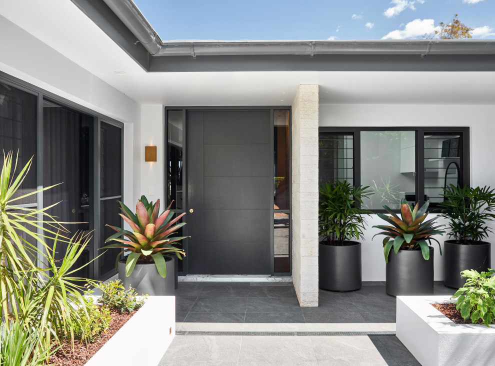 Design ideas for a mid-sized contemporary front door in Sydney with white walls, ceramic floors, a single front door, a black front door, grey floor and brick walls.