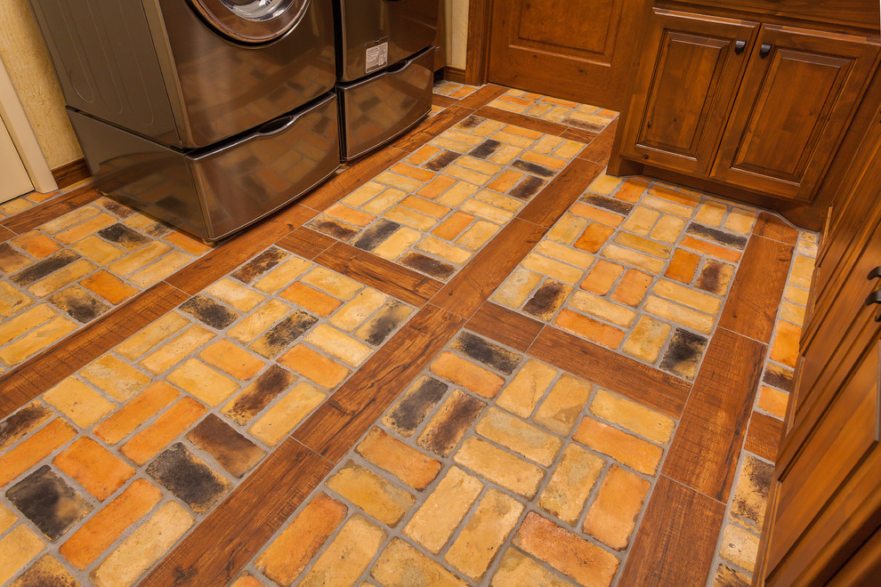 Example of a mid-sized mountain style u-shaped brick floor home design design in Dallas with raised-panel cabinets, medium tone wood cabinets, granite countertops, beige walls and a side-by-side washer/dryer