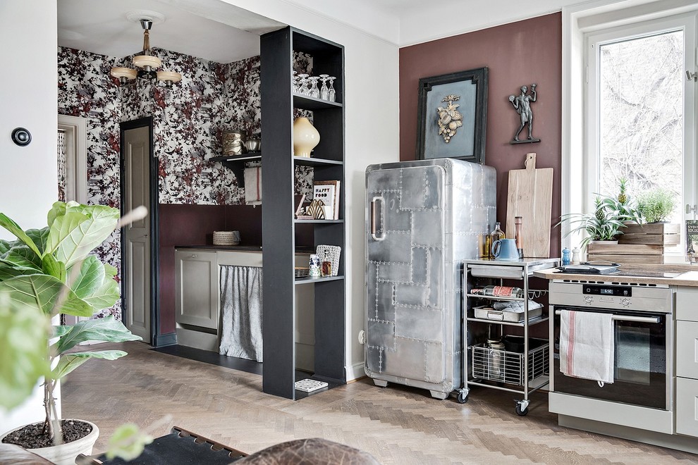 Inspiration for a small eclectic single-wall open plan kitchen in Malmo with stainless steel appliances, no island, light hardwood floors and beige floor.