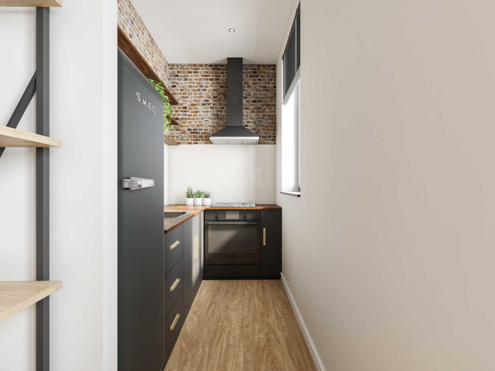 Design ideas for a small industrial l-shaped separate kitchen in London with a drop-in sink, flat-panel cabinets, black cabinets, wood benchtops, white splashback, ceramic splashback, black appliances and light hardwood floors.