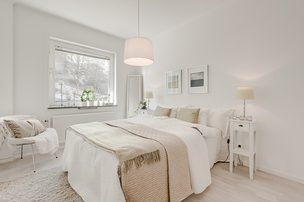 This is an example of a mid-sized scandinavian master bedroom in Stockholm with white walls, light hardwood floors and no fireplace.