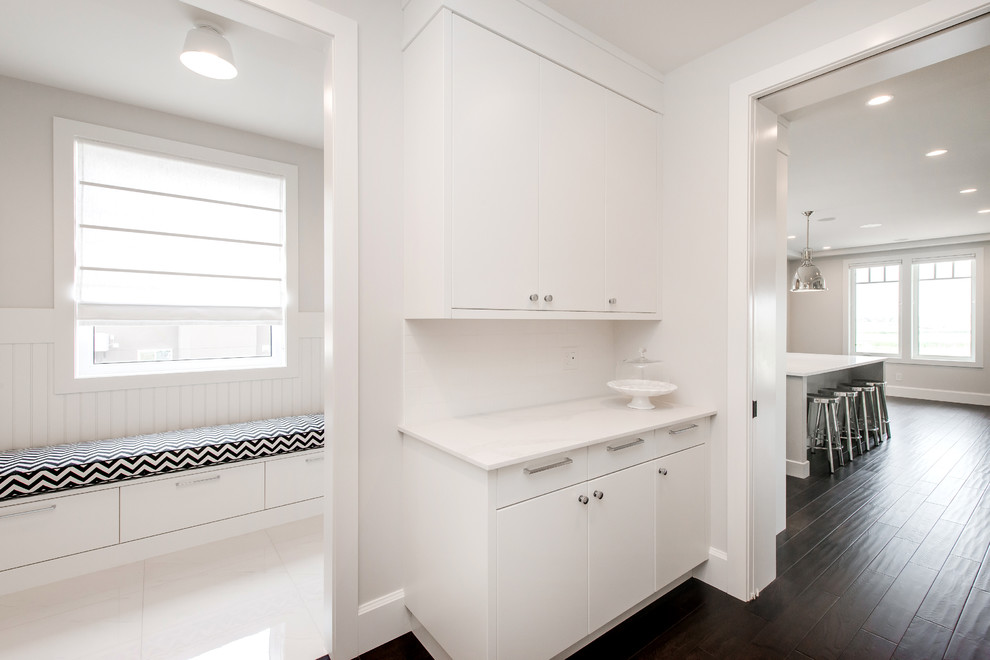 Inspiration for a large transitional mudroom in Calgary with white walls and dark hardwood floors.