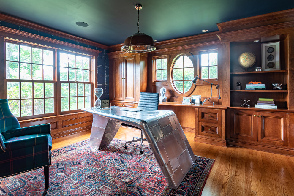 Idéer för mellanstora vintage hemmabibliotek, med blå väggar, mellanmörkt trägolv, ett fristående skrivbord och brunt golv