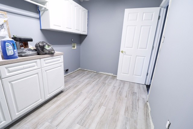 Small beach style laundry room in Miami with white cabinets, grey walls, porcelain floors and grey floor.