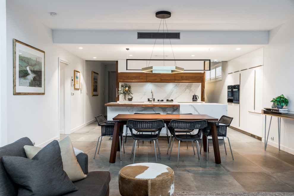 This is an example of a contemporary open plan dining in Brisbane with white walls, concrete floors and grey floor.