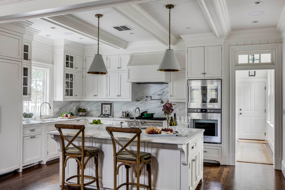 Inspiration for a mid-sized country l-shaped kitchen in Boston with recessed-panel cabinets, white cabinets, marble benchtops, white splashback, marble splashback, panelled appliances, with island, brown floor, white benchtop, an undermount sink and dark hardwood floors.