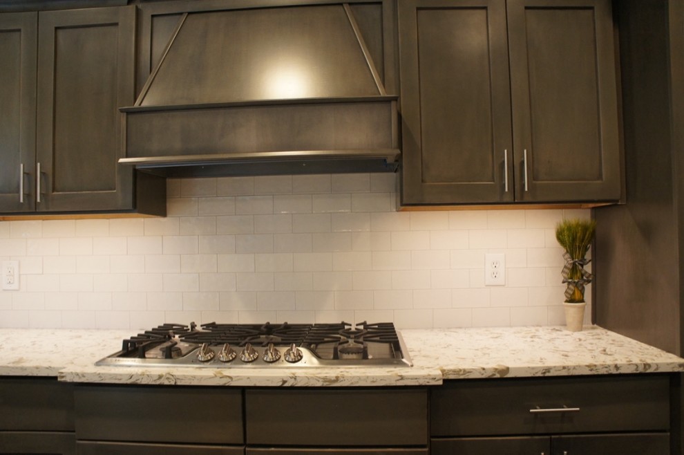 Transitional u-shaped eat-in kitchen photo with flat-panel cabinets, white backsplash, stainless steel appliances and an island