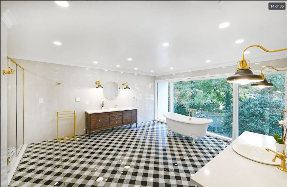 This is an example of an expansive transitional master bathroom in New York with louvered cabinets, brown cabinets, a claw-foot tub, a corner shower, a bidet, white tile, porcelain tile, white walls, porcelain floors, a drop-in sink, engineered quartz benchtops, multi-coloured floor, a hinged shower door, white benchtops, a single vanity and a freestanding vanity.