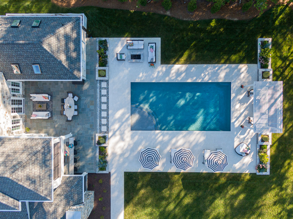 Inspiration for an expansive classic back rectangular lengths swimming pool in Richmond with natural stone paving.