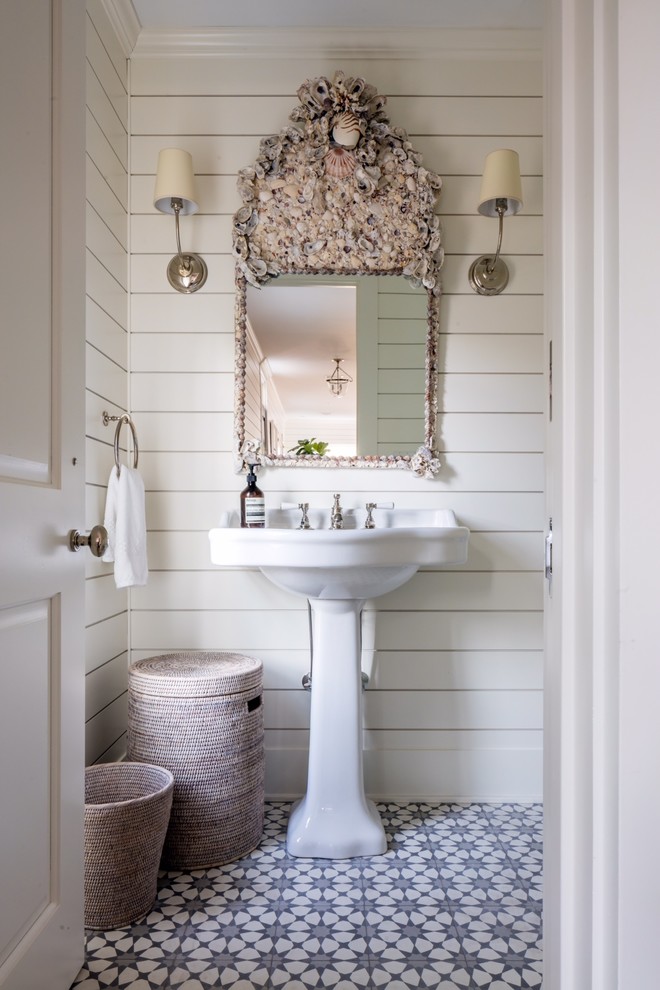 Inspiration for a mid-sized beach style powder room in New York with multi-coloured tile, blue tile, white tile, white walls, a pedestal sink and cement tiles.