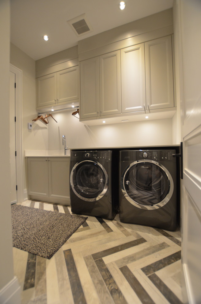 This is an example of a transitional laundry room in Toronto.