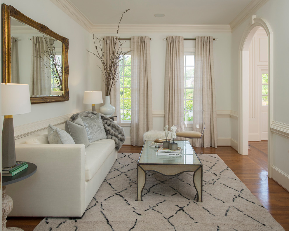 This is an example of a traditional formal enclosed living room in Atlanta with white walls and medium hardwood floors.