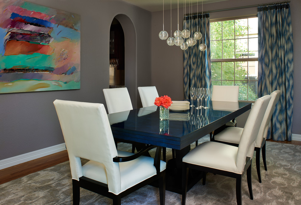 Example of a transitional medium tone wood floor dining room design in Denver with purple walls