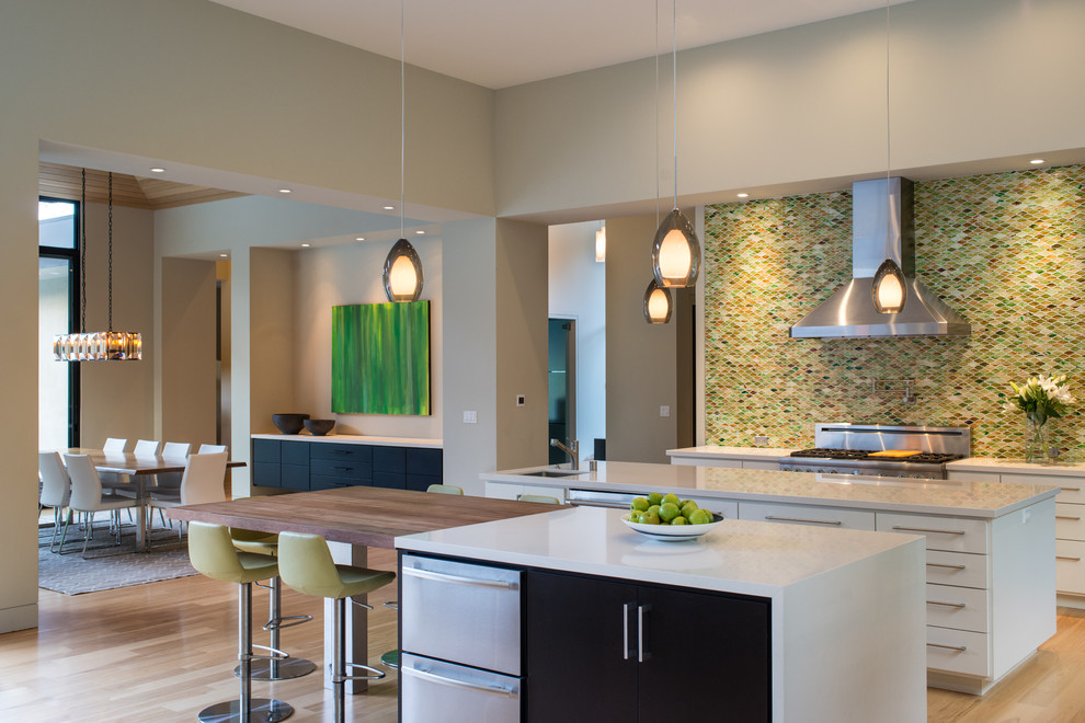 Design ideas for a contemporary eat-in kitchen in San Francisco with an undermount sink, flat-panel cabinets, white cabinets, multi-coloured splashback, mosaic tile splashback, stainless steel appliances, light hardwood floors and multiple islands.