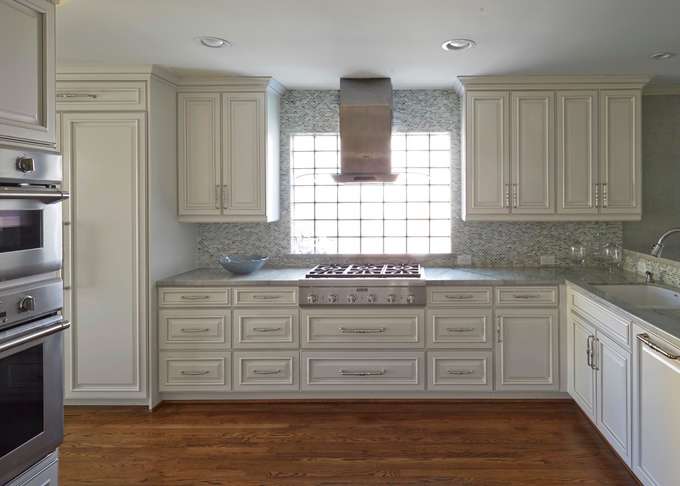 Kitchen - transitional medium tone wood floor kitchen idea in Houston with white cabinets, granite countertops, multicolored backsplash, stainless steel appliances and no island