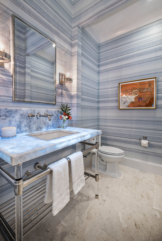 This is an example of a beach style powder room in Miami with blue walls, an undermount sink, grey floor and white benchtops.